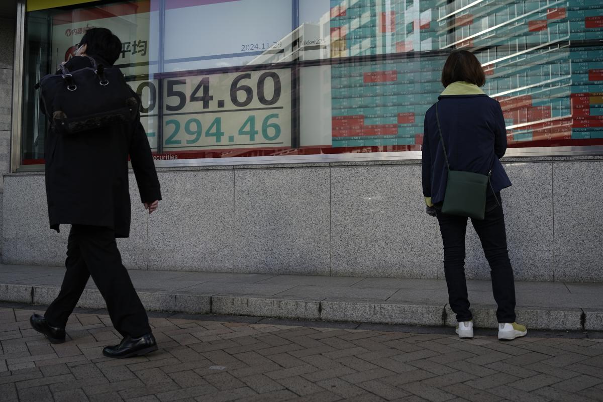 Two human beings in front of building with price numbers.